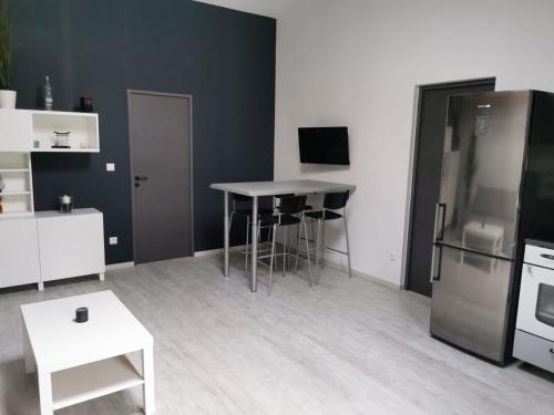 a living room with a table and a refrigerator at LE CHAI in Castelnau-de-Guers