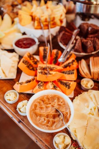 a table full of cheese and other food items at Pousada Montanhas do Sol in São Lourenço