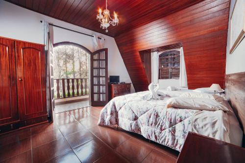 a bedroom with a bed and a wooden wall at Pousada Montanhas do Sol in São Lourenço
