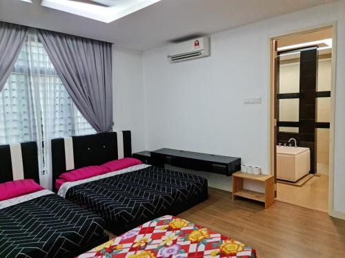 a bedroom with two beds and a mirror at Pearl Residences Sleep 27 in Batu Ferringhi