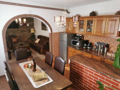 cocina y sala de estar con mesa de madera y mesa en House Leyla, en Bihać