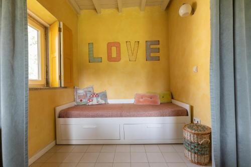a room with a bed with the word love on the wall at Chão do Rio - Turismo de Aldeia in Seia