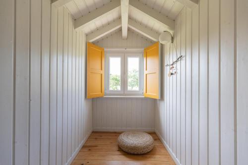 a small room with a window and a ottoman at Chão do Rio - Turismo de Aldeia in Seia