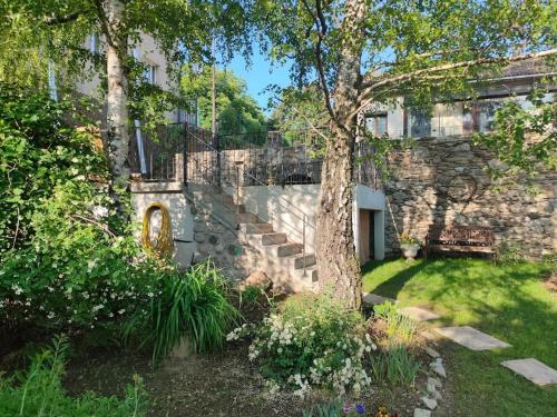 a stone building with a bench and a tree at Le Secret du Moulin, agréable tiny house Villefort in Villefort