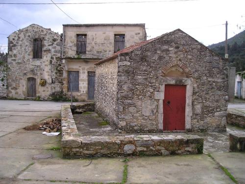 an old stone building with a red door at Villa Aloni in Fílippos