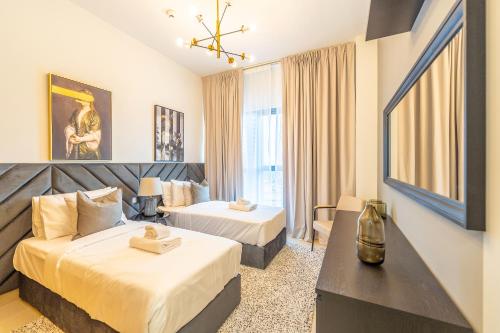 Habitación de hotel con 2 camas y escritorio en Spacious Art Deco Apt with Burj & Canal Views, en Dubái