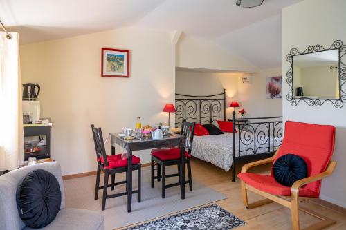 un salon avec une table et des chaises et un lit dans l'établissement B&B Le Bois Berranger, à Saint-Urbain