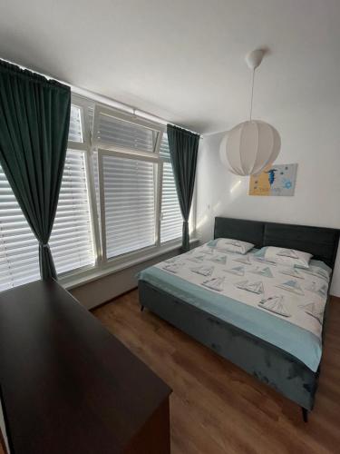 sypialnia z łóżkiem w pokoju z oknami w obiekcie Oliver w Ankaranie