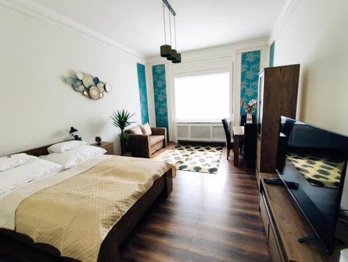 a bedroom with a bed and a living room at Central Palace Apartman in Debrecen