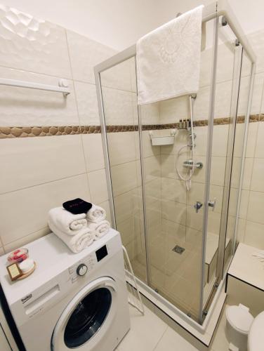 a bathroom with a washing machine and a shower at Central Palace Apartman in Debrecen