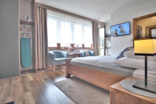 a bedroom with a bed and a desk and a chair at Pokoje w CENTRUM "CICHA" in Zakopane