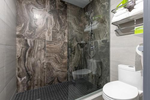 a bathroom with a shower and a toilet at Auberge L'Étape in Mont-Laurier