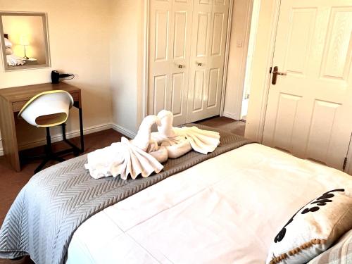 a bedroom with a bed with two swans sitting on it at Beautiful 3-bedroom house, city centre, parking in Norwich