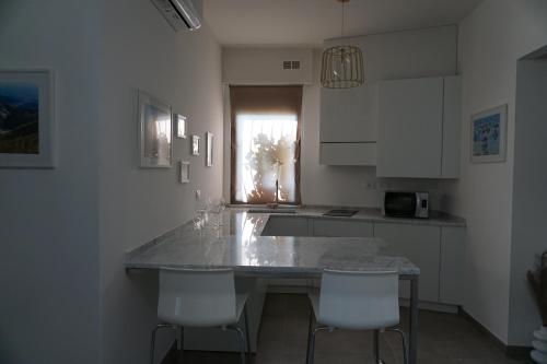 a kitchen with a marble counter top and white cabinets at La Casina in Carrara