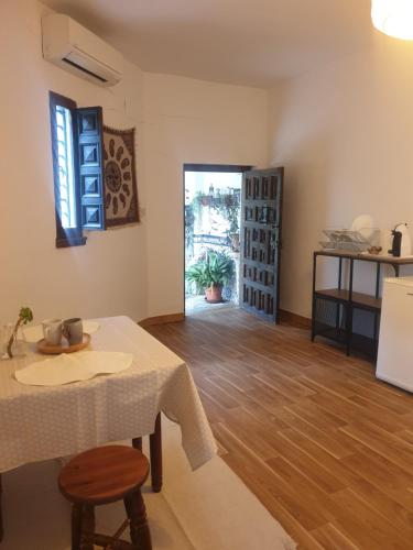 ein Wohnzimmer mit einem Tisch und einer Küche in der Unterkunft Aljibe del Albayzin in Granada