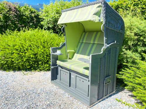 a green pergola sitting in a garden at Hotel Grachtenhuus Greetsiel in Greetsiel