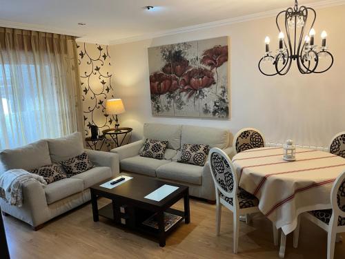 - un salon avec un canapé et une table dans l'établissement Apartamento ALBAMAR SANXENXO, à Sanxenxo