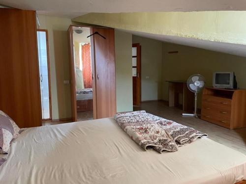 ein Schlafzimmer mit einem Bett mit einer weißen Tagesdecke in der Unterkunft Vila George in Eforie Sud