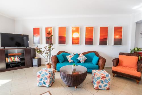 a living room with a blue couch and two chairs at Dilina Studios in Arkasa
