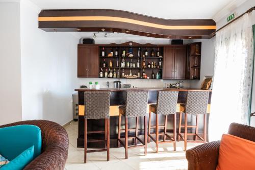 a kitchen with a bar with bar stools at Dilina Studios in Arkasa