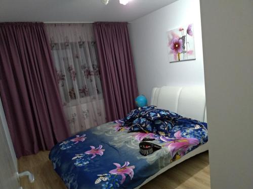 a bedroom with a bed with a blue comforter at Cozy Popesti in Popeşti-Leordeni