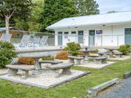 a group of picnic tables and chairs in front of a building at Beach Bum West-O Motel in Ocean City