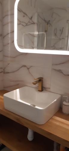 a bathroom with a white sink and a mirror at Brzegiem morza in Gdańsk