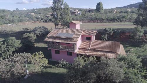 an aerial view of a pink house in a field at Casa do Vani - Lapinha da Serra in Santana do Riacho