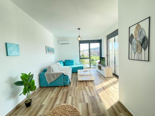 a living room with a blue couch and a window at MaNora in Ulcinj