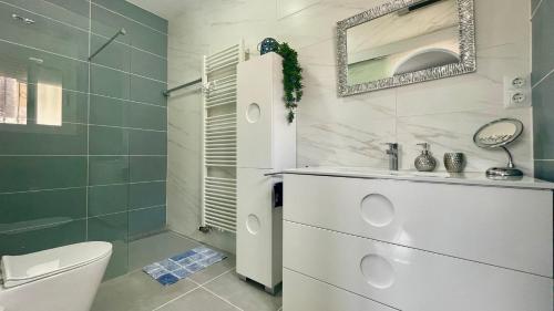a bathroom with a sink and a toilet and a mirror at MEDDAYS VILLA NOAH in Miami Platja