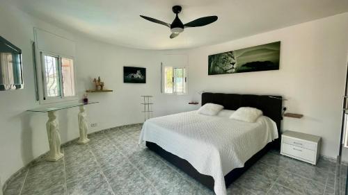 a bedroom with a bed and a ceiling fan at MEDDAYS VILLA NOAH in Miami Platja