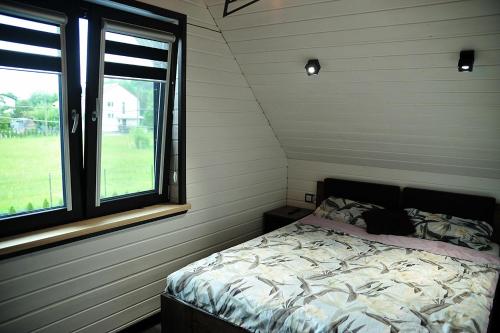 um quarto com uma cama num quarto com uma janela em Domki u Biesiady em Lesko