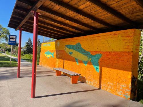 a mural of a fish on a wall next to a bench at Piejūras māja skandināvu stilā! Seaside scandi house! in Lapmežciems