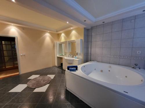 baño grande con bañera y lavamanos en EDEN Residence, en Skopje