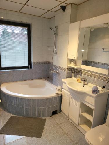 a bathroom with a large tub and a sink at EDEN Residence in Skopje
