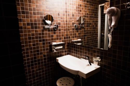 a bathroom with a sink and a mirror at Pension Baranek - Baranek Resorts in Kaprun
