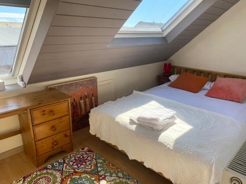 a attic bedroom with a bed and a window at Beautiful Brighton House - Free Parking in Portslade