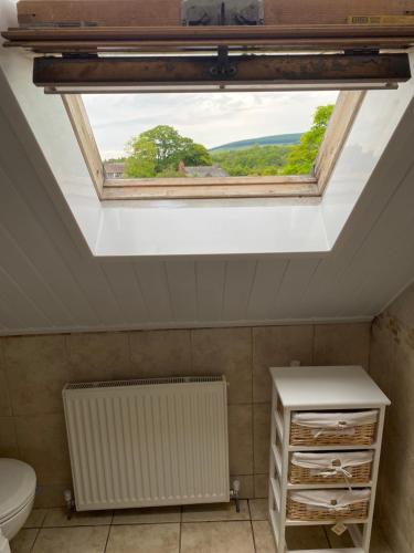 a skylight in a bathroom with a radiator and a window at Riverbank Cottage Lake District Double Balcony in Egremont