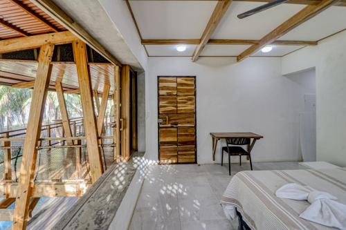 a bedroom with a bed and a table and a window at Mangue House in Playa San Miguel 