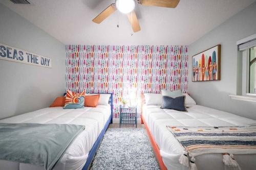 a bedroom with two beds and a window at Beach house w/Putting Green/Game Rm/Rooftop Deck in Cocoa Beach
