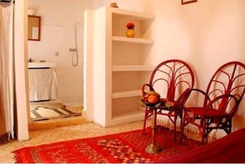 a room with two chairs and a table and a kitchen at Riad Dar Latifa in Essaouira