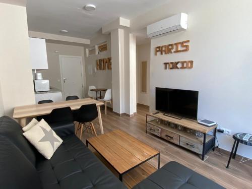 ein Wohnzimmer mit einem Sofa und einem Flachbild-TV in der Unterkunft Apartamentos San Miguel in Torremolinos