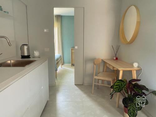 eine Küche mit einem Tisch, einem Waschbecken und einem Spiegel in der Unterkunft maestranze in Matera