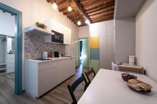 una cucina con armadi bianchi e tavolo con sedie di Florence David's Guesthouse a Firenze