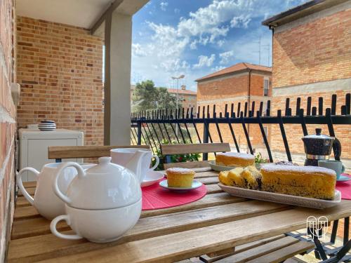 uma mesa com um bule de chá e bolo numa varanda em maestranze em Matera