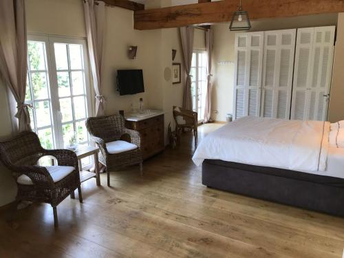 a bedroom with a bed and a desk and chairs at Villa La Begude in Saint-Tropez