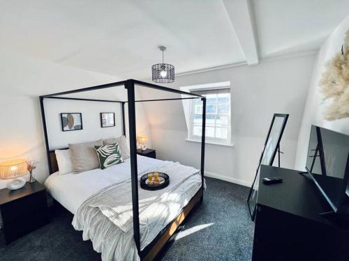 a bedroom with a bed with a black canopy at 2 Bed Harbourside Penthouse with Hot Tub & Roof Terrace in Weymouth