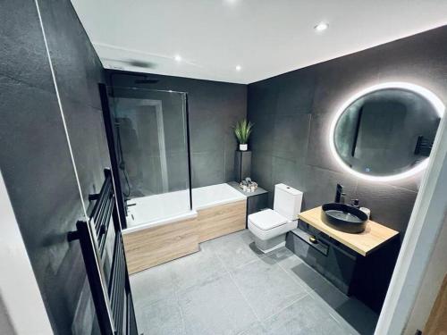 a bathroom with a tub and a sink and a toilet at 2 Bed Harbourside Penthouse with Hot Tub & Roof Terrace in Weymouth