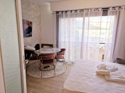 1 dormitorio con cama, mesa y ventana en Central Monaco Studio, en Montecarlo