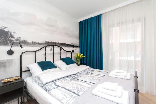 sypialnia z dużym łóżkiem z niebieskimi akcentami w obiekcie Apartament 54 Old Town w Gdańsku